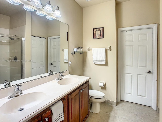 bathroom featuring tile patterned flooring, vanity, toilet, and walk in shower