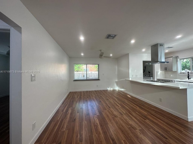 unfurnished living room with ceiling fan, dark hardwood / wood-style flooring, and sink