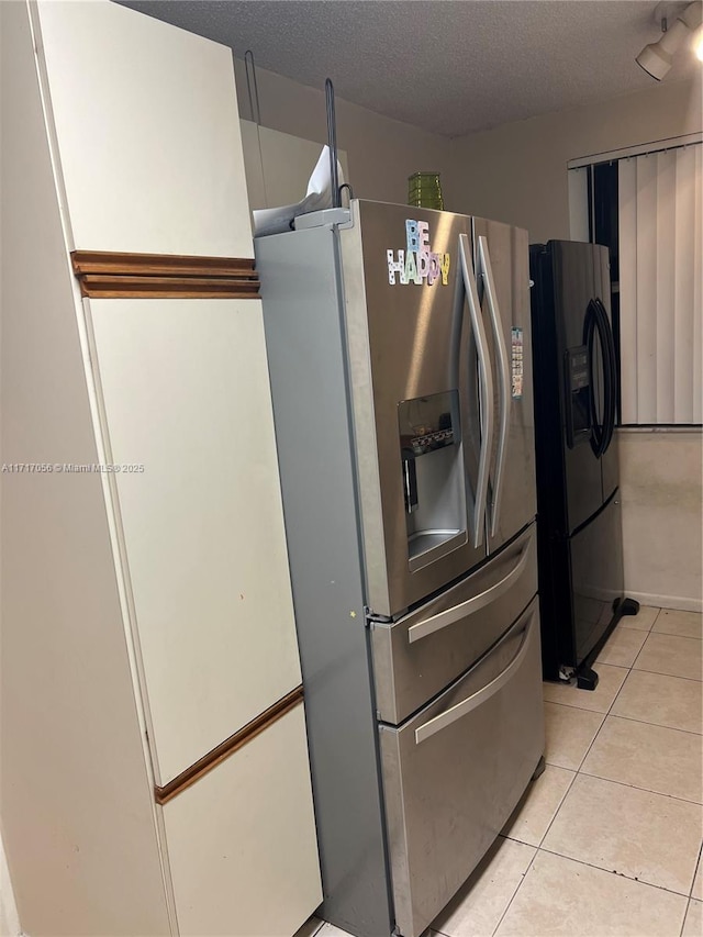 kitchen featuring stainless steel refrigerator with ice dispenser, a textured ceiling, light tile patterned floors, and fridge with ice dispenser