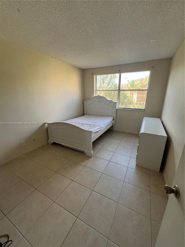 unfurnished bedroom featuring light tile patterned flooring and a textured ceiling