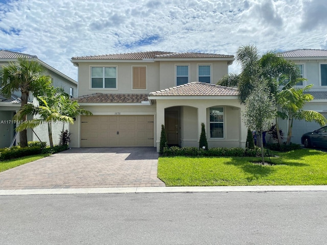 mediterranean / spanish house featuring a garage and a front lawn