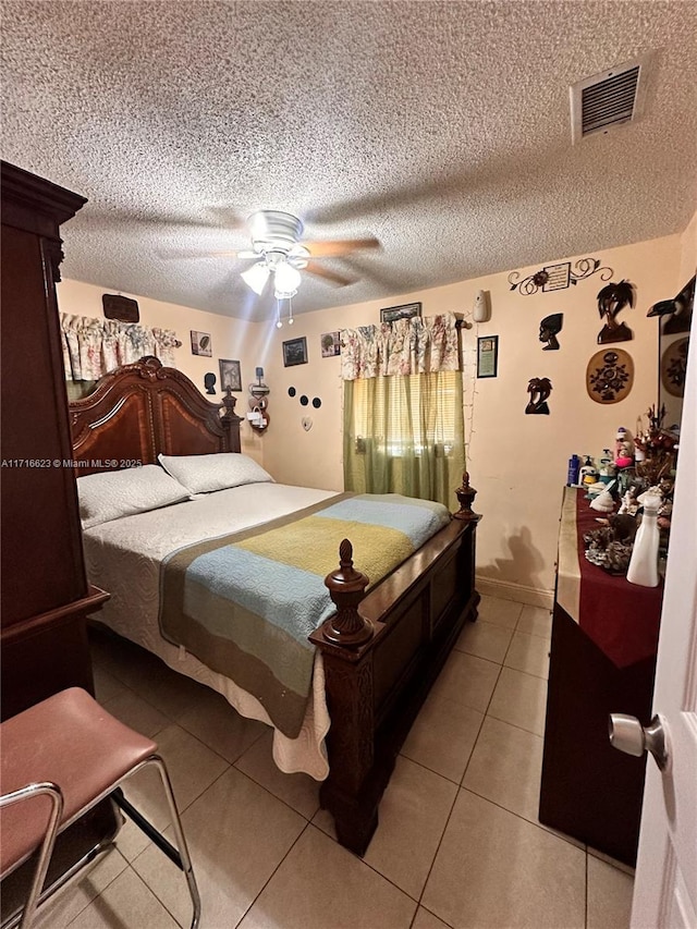 tiled bedroom featuring ceiling fan and a textured ceiling