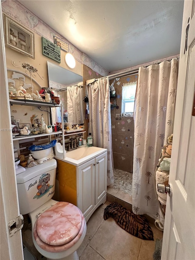 bathroom with tile patterned flooring, vanity, toilet, and walk in shower