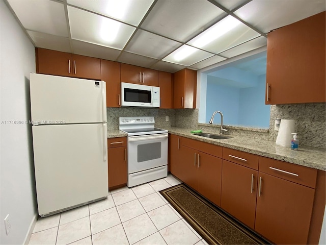 kitchen featuring light tile patterned flooring, white appliances, tasteful backsplash, and sink