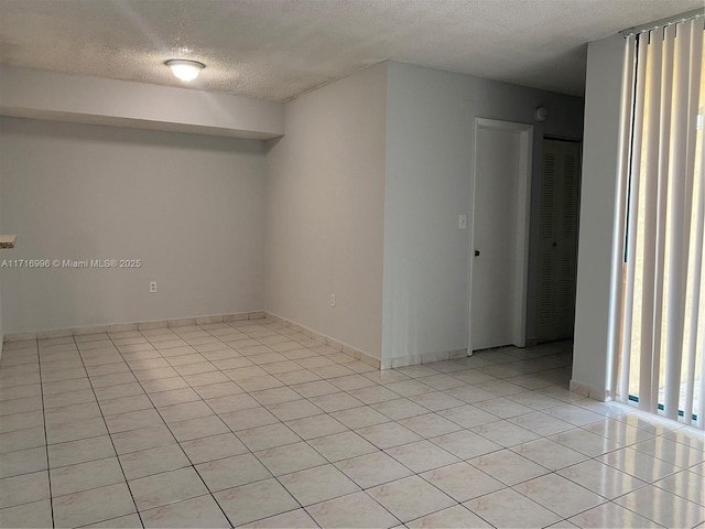 tiled spare room with a textured ceiling