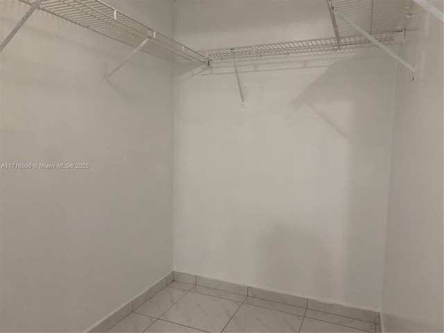 walk in closet featuring light tile patterned flooring