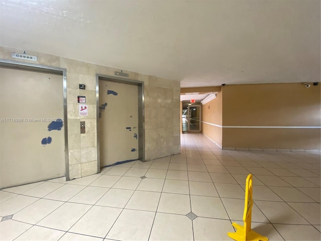 hall with elevator and light tile patterned flooring