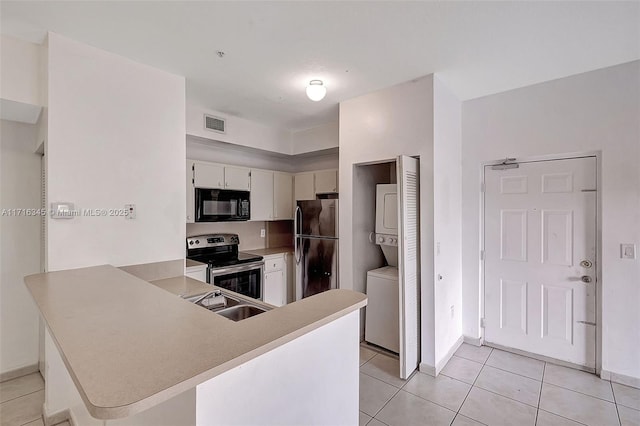 kitchen featuring sink, stainless steel appliances, kitchen peninsula, light tile patterned flooring, and stacked washer and clothes dryer