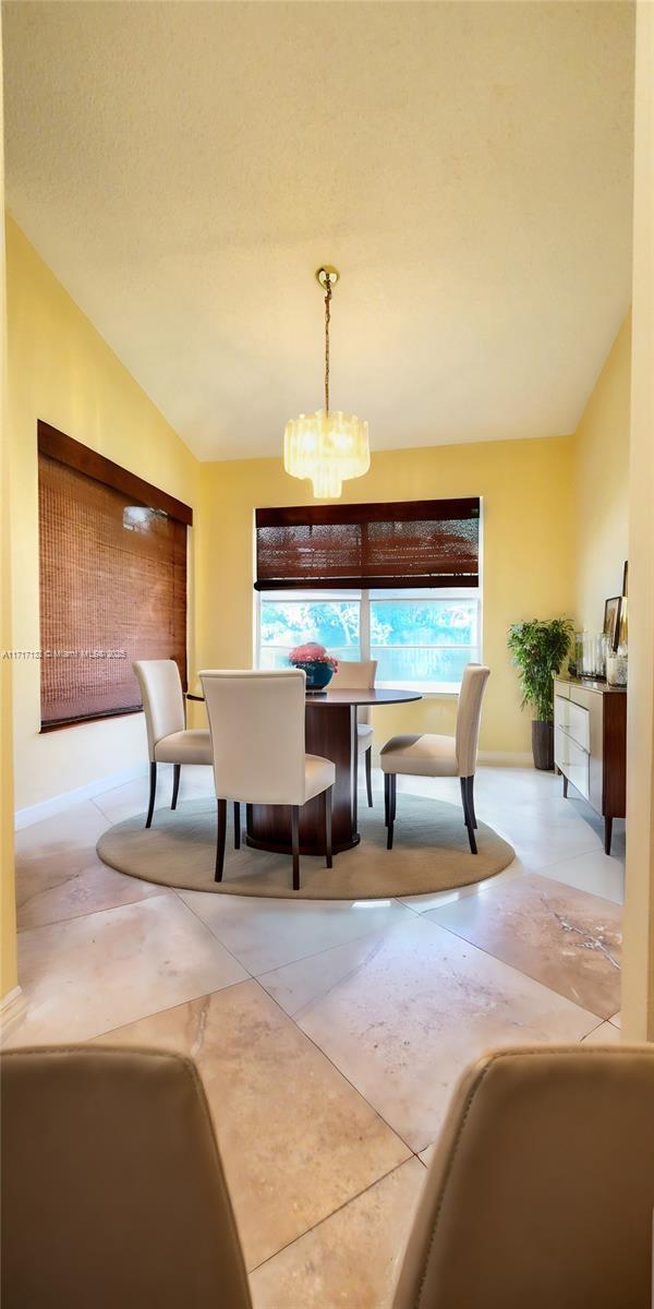 dining space featuring a notable chandelier and lofted ceiling