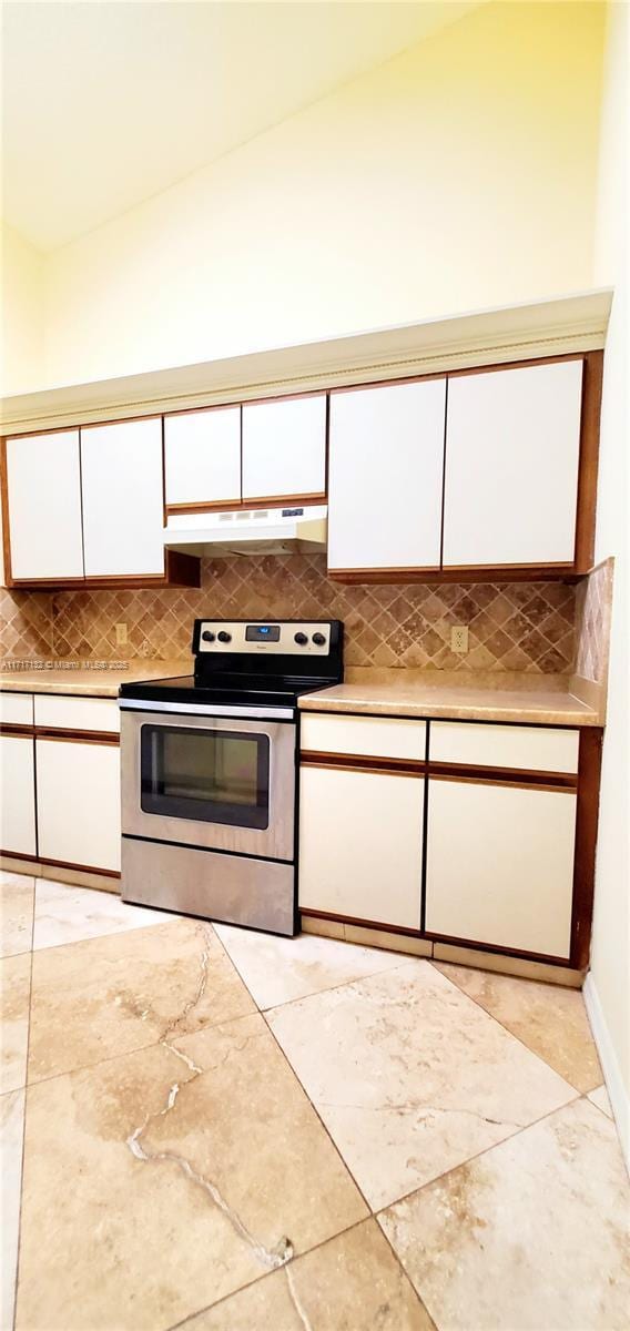 kitchen featuring stainless steel electric stove, white cabinets, and vaulted ceiling