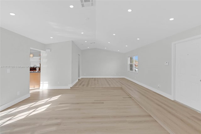 interior space with lofted ceiling and light hardwood / wood-style flooring