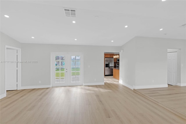 unfurnished living room featuring french doors and light hardwood / wood-style floors