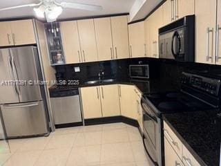 kitchen with sink, ceiling fan, cream cabinetry, light tile patterned flooring, and stainless steel appliances