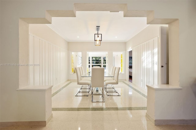 dining area featuring crown molding and baseboards