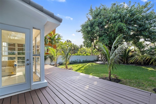 wooden terrace with fence, a yard, and french doors