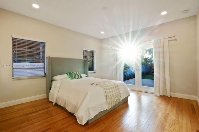 bedroom featuring access to outside, wood finished floors, french doors, and baseboards