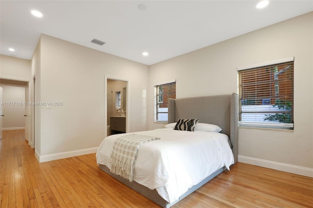 bedroom featuring light wood-type flooring, visible vents, multiple windows, and baseboards