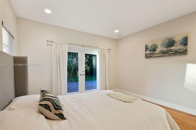 bedroom featuring wood finished floors, access to outside, multiple windows, baseboards, and french doors