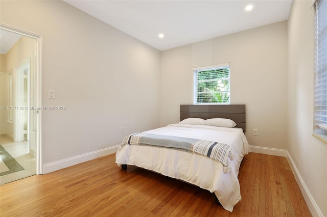 bedroom featuring baseboards, light wood-type flooring, and recessed lighting