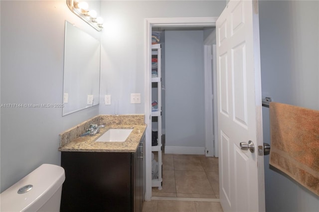 bathroom with tile patterned flooring, vanity, and toilet