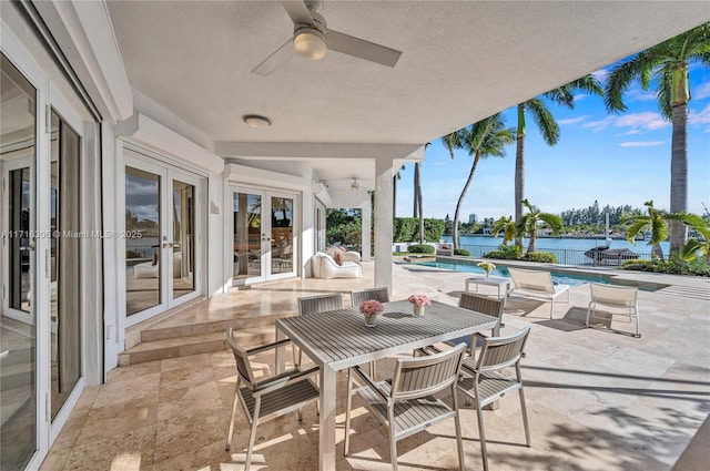 view of patio with french doors, a water view, and ceiling fan