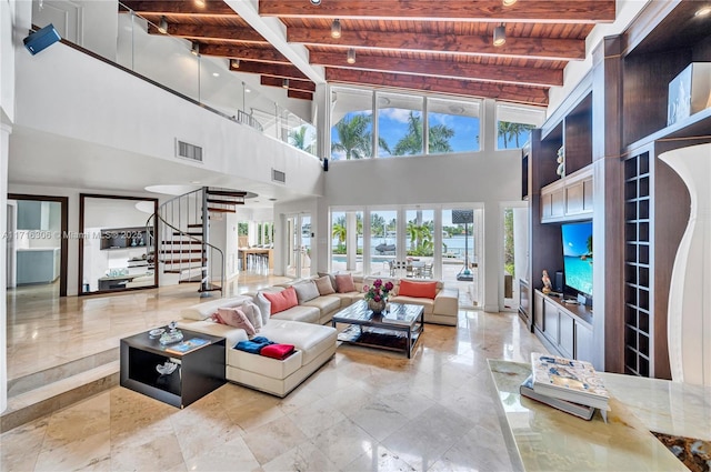 living room with beam ceiling, wooden ceiling, and a towering ceiling