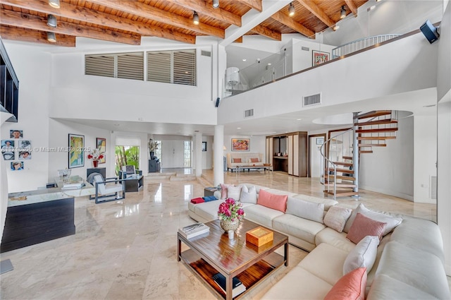 living room featuring beam ceiling, a towering ceiling, and wood ceiling