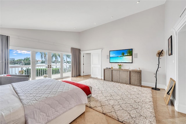 bedroom with access to exterior, a high ceiling, a water view, and french doors