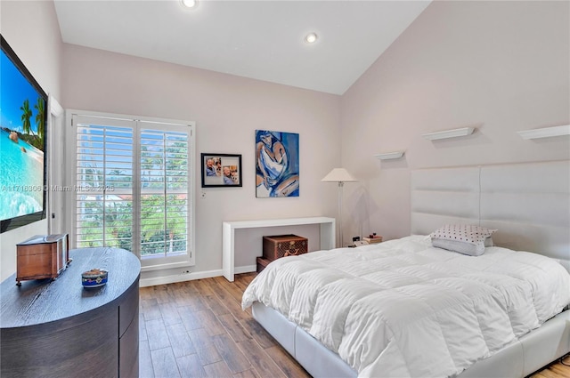 bedroom featuring light wood-type flooring and vaulted ceiling