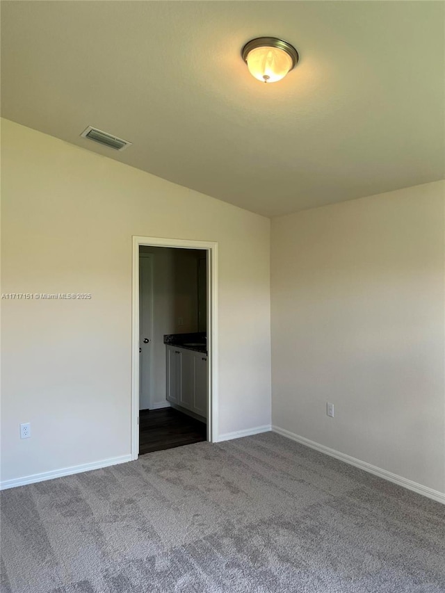 unfurnished bedroom featuring carpet floors and lofted ceiling