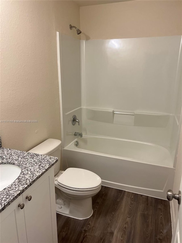 full bathroom featuring hardwood / wood-style floors, vanity, toilet, and  shower combination