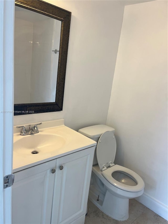 bathroom with toilet, vanity, and tile patterned floors