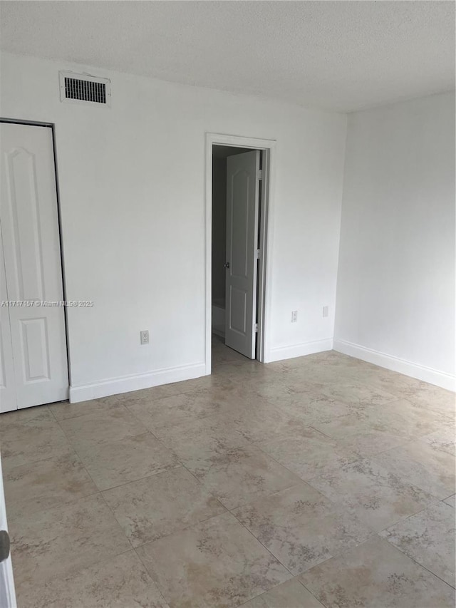 unfurnished room with a textured ceiling