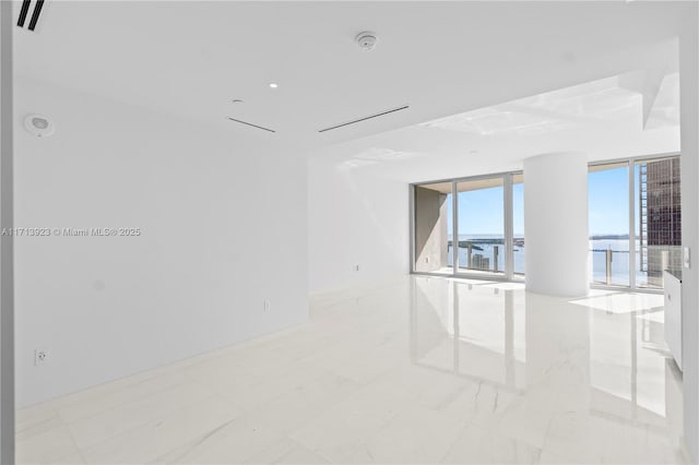 unfurnished room featuring a water view and floor to ceiling windows