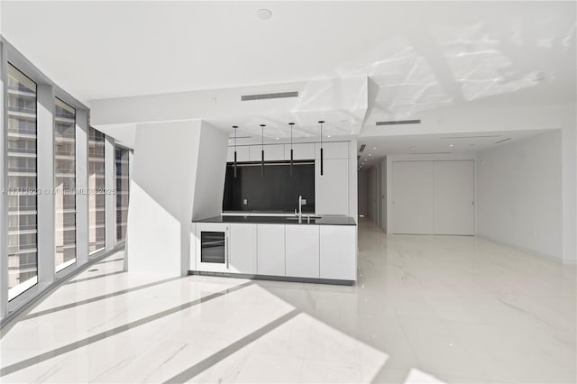 kitchen with white cabinetry, sink, and decorative light fixtures