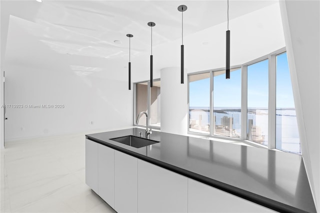 kitchen with pendant lighting, sink, and white cabinets