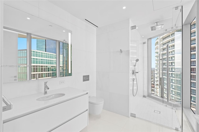 bathroom featuring tile patterned flooring, tile walls, vanity, toilet, and walk in shower