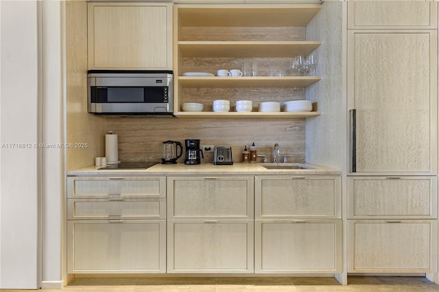 bar featuring decorative backsplash, black electric cooktop, and sink