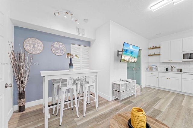 dining area featuring sink and light hardwood / wood-style floors