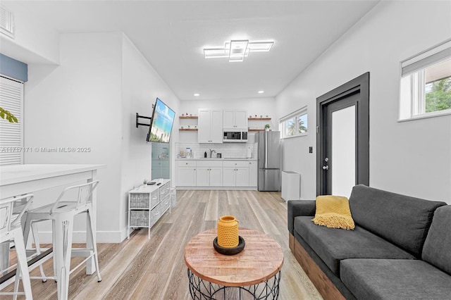 living room featuring sink and light hardwood / wood-style floors