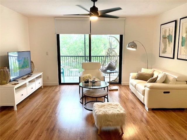 living room with ceiling fan and light hardwood / wood-style floors