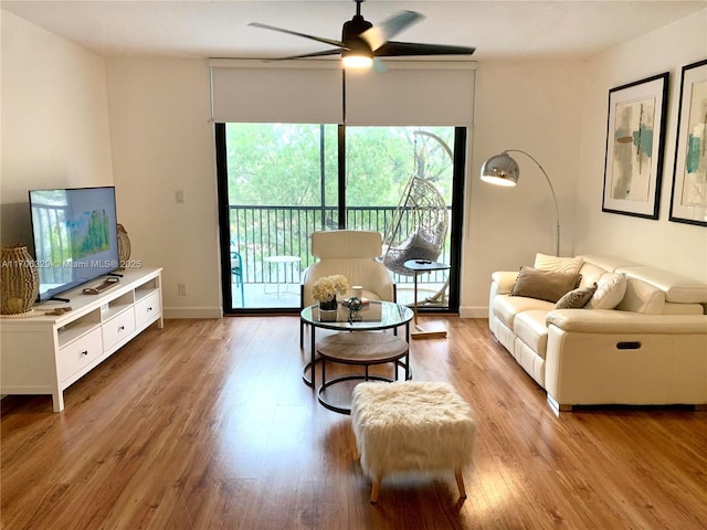 living room featuring ceiling fan and light hardwood / wood-style flooring