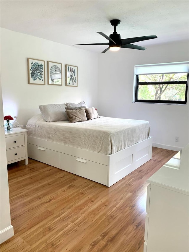 bedroom with light wood-type flooring and a ceiling fan