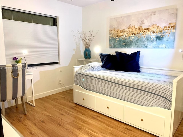 bedroom featuring light wood-style flooring and baseboards