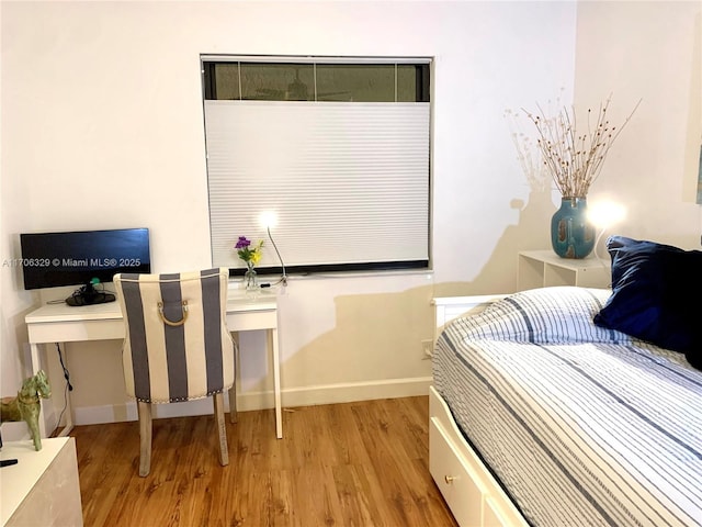 bedroom featuring wood finished floors and baseboards