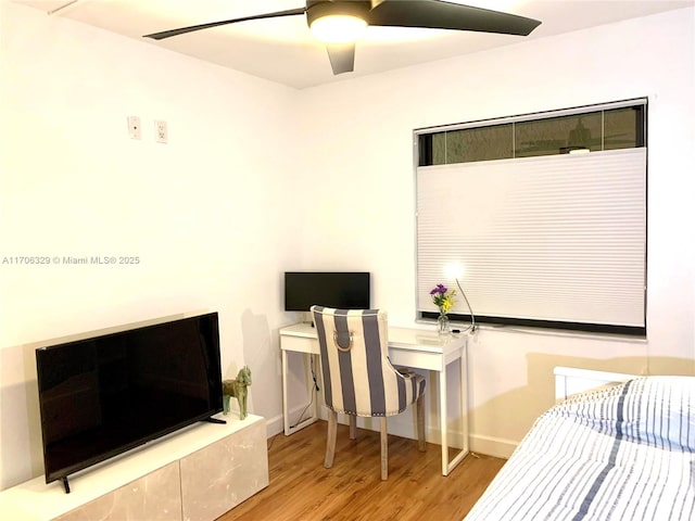 bedroom featuring ceiling fan, baseboards, and wood finished floors