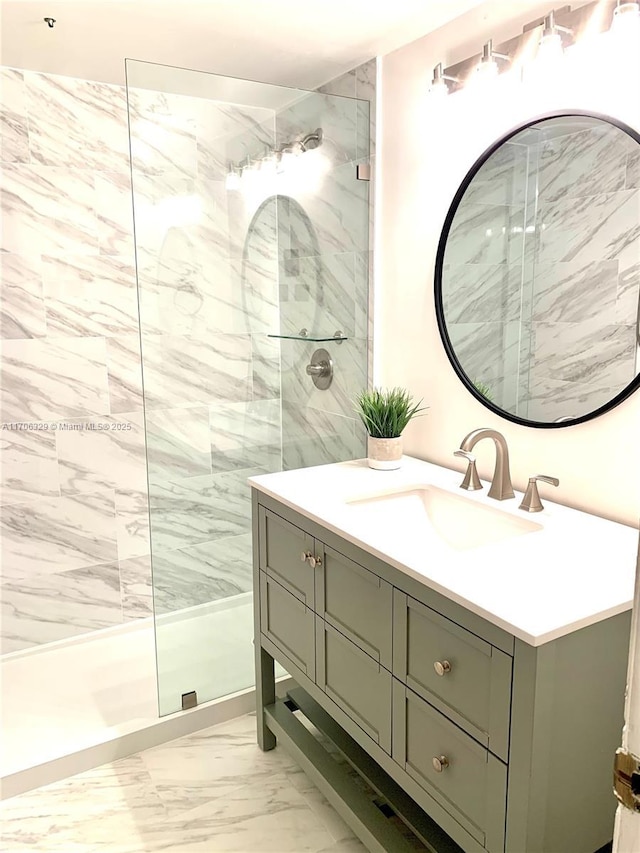 bathroom with a tile shower and vanity