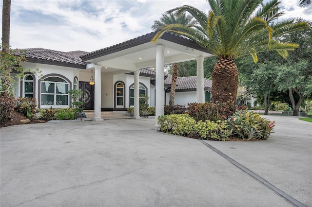 exterior space with a tiled roof and stucco siding