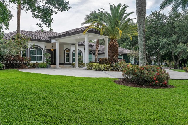 13431 Old Sheridan St, Southwest Ranches, FL 33330 - back of house featuring a tiled roof, a yard, and stucco siding