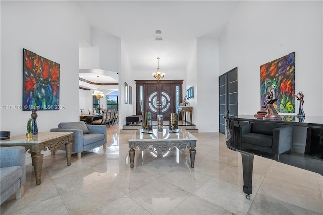 interior space with marble finish floor, visible vents, a high ceiling, and a chandelier